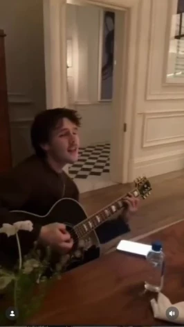 Krūzs Bekhems spēlē pavadījumu uz ģitāras, kamēr mamma ar kolēģēm dzied.