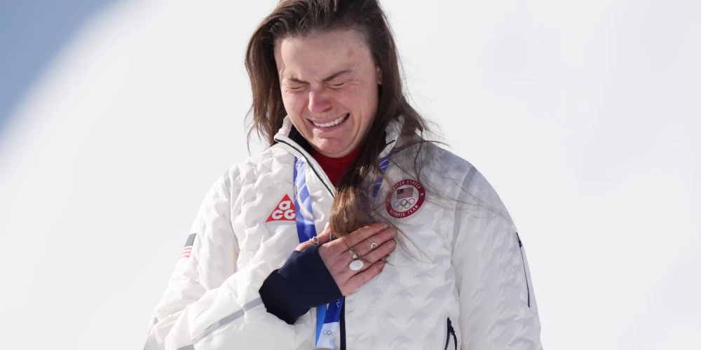 Brīzija Džonsone emocionāla uz goda pjedestāla, tobrīd vēl medaļa droši karājas viņas kaklā.