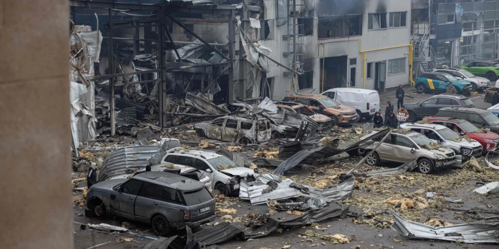 Местные жители осматривают поврежденные автомобили на месте российского удара в Одессе 13 февраля 2026 года на фоне российского вторжения в Украину.