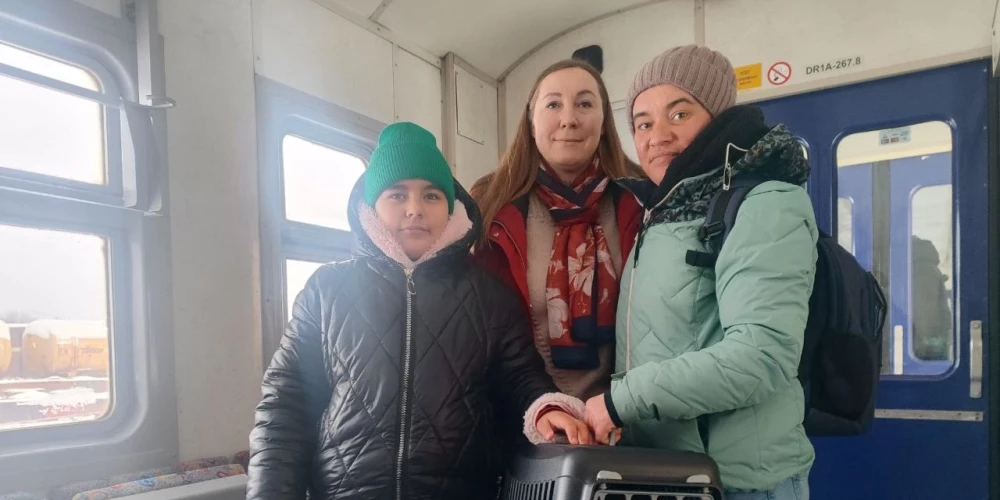 Evita Savicka (centrā) vilcienā Daugavpils dzelzceļa stacijā pavada Ukrainas bēgļus no Čerņivciem – Jūliju un viņas meitu Sofiju. Būrī – kaķis Rudiņš.