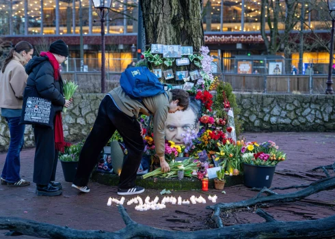 Сторонники покойного российского оппозиционного лидера Алексея Навального возлагают цветы к стихийному мемориалу, установленному на площади в Амстердаме, в день второй годовщины его смерти в заключении.