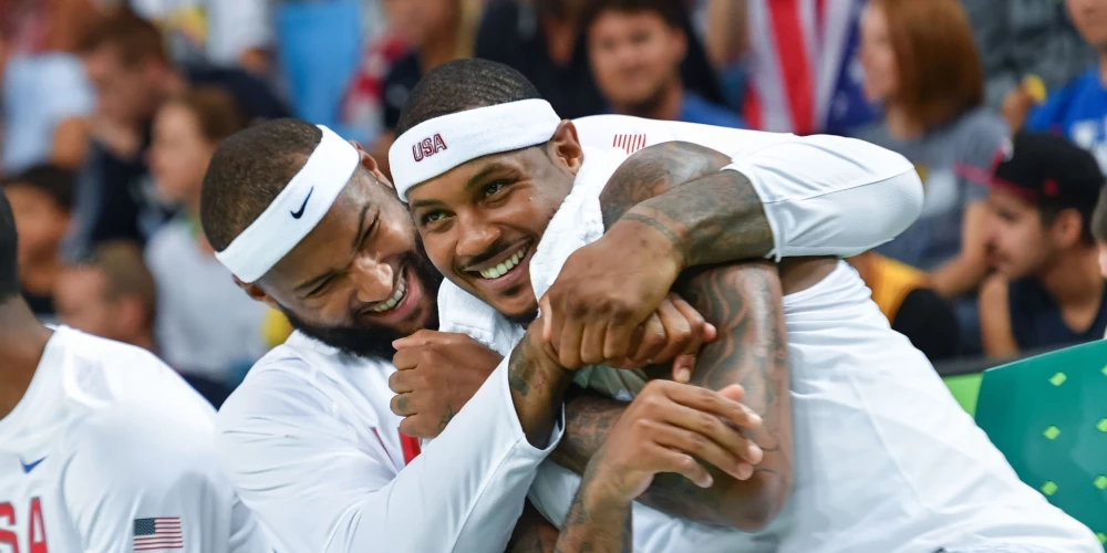ASV centra spēlētājs Demarkuss Kazinss (pa kreisi) joko ar komandas biedru Karmelo Entoniju basketbola spēles laikā pret Venecuēlu olimpiskajās spēlēs Riodežaneiro, Brazīlijā, 2016. gada 8. augustā. ASV izlase toreiz bez lielām pūlēm uzvarēja Venecuēlu ar 113:69.