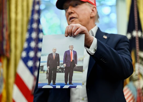 ASV prezidents Donalds Tramps tur rokās fotogrāfiju, kurā redzams viņš un Krievijas vadonis Vladimirs Putins.