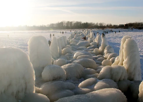 Cilvēki pie apledojuša Engures mola ziemā.