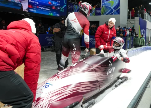Latvijas bobslejisti Jēkabs Kalenda un Matīss Miknis bobsleja divnieku sacensībās Kortīnas bobsleja, skeletona un kamaniņu trasē 2026. gada Milānas un Kortīnas ziemas olimpiskajās spēlēs Itālijā.