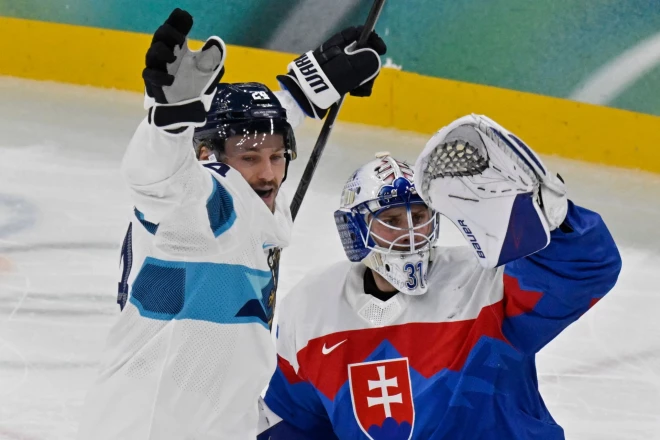 Somijas spēlētājs Rūpe Hincs līksmo blakus Slovākijas spēlētājam Samuelam Hlavajam pēc tam, kad guva savas komandas trešos vārtus.