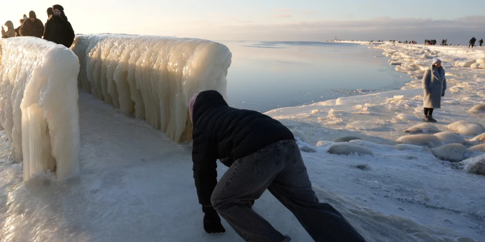 Cilvēki un apledojusi skatu platforma Mangaļsalas molā 2026. gada 31. janvārī.