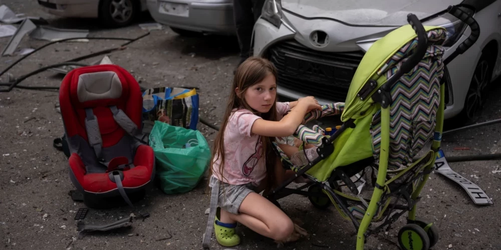 10-летняя Полина присматривает за своей 3-летней сестрой Мариной возле детской больницы "Охматдет" в Киеве.