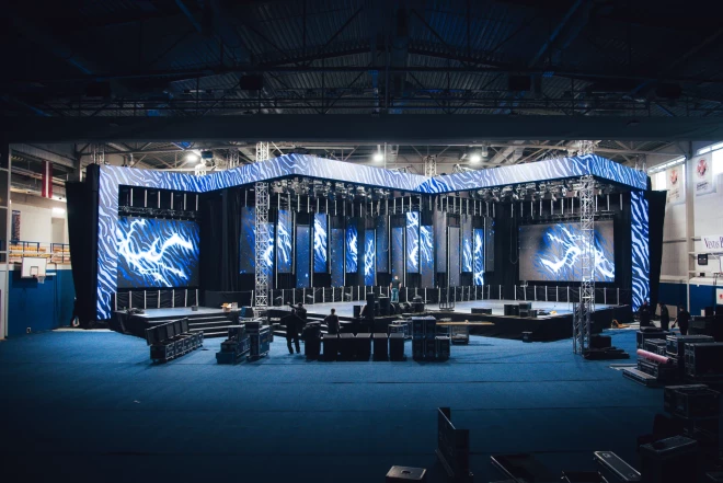 Iespaidīgā 34 metrus garā skatuves būve top scenogrāfa Pāvela Armaņa vadībā, un tā solās kļūt par vienu no vērienīgākajām skatuves konstrukcijām, kāda jelkad tapusi Ventspils olimpiskajā centrā. 