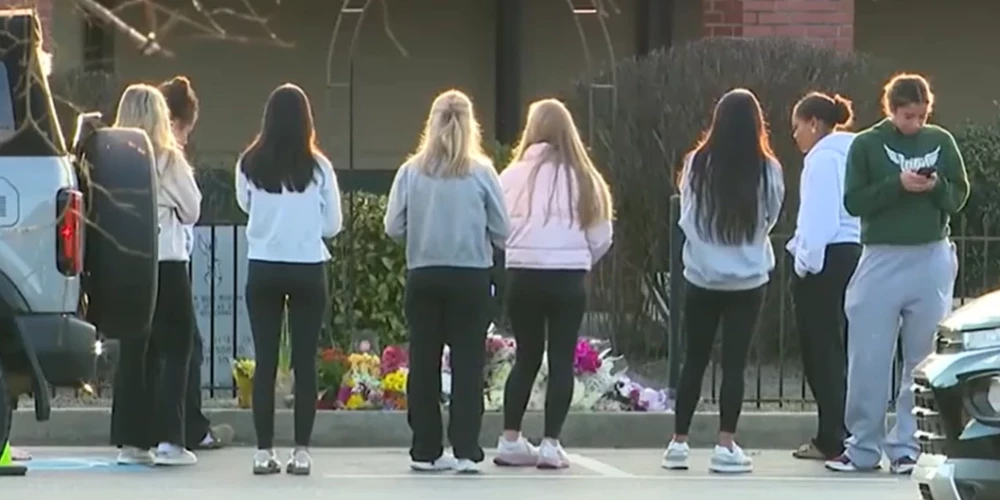 Skolnieki pie Northolas vidusskolas piemin traģiski bojā gājušo skolotāju Džeisonu Hjūzu (ekrānuzņēmums no video)