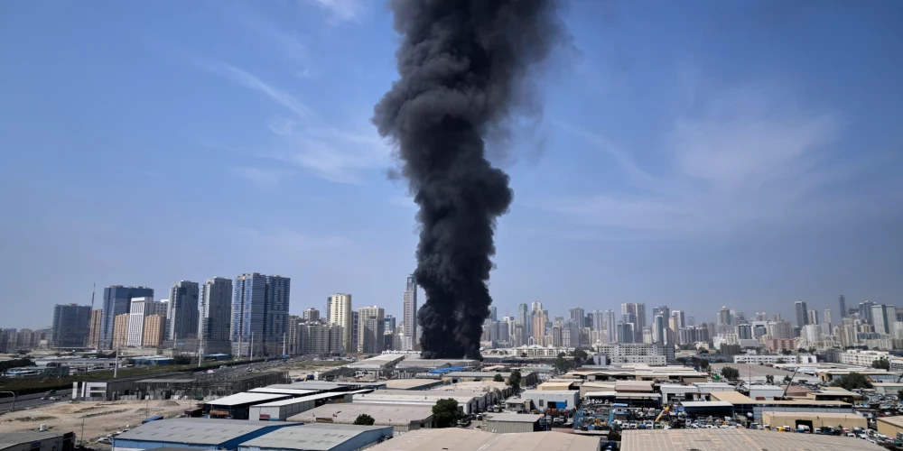Черный столб дыма поднимается над складом в промышленной зоне города Шарджа в Объединенных Арабских Эмиратах после сообщений об ударах Ирана по Дубаю.