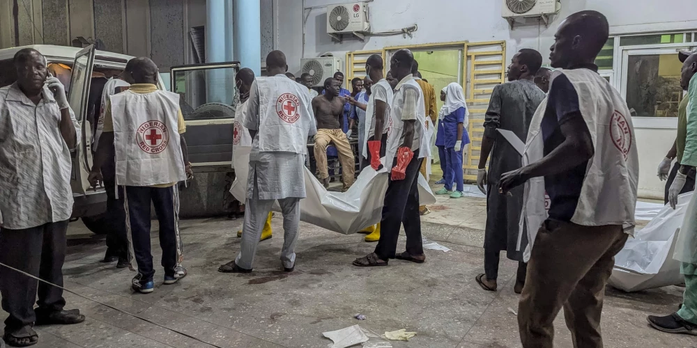 Pēc vairākiem sprādzieniem Nigērijas Borno štata centrā Maiduguri. Nigērijas Sarkanā Krusta darbinieki nes līķus maisos.