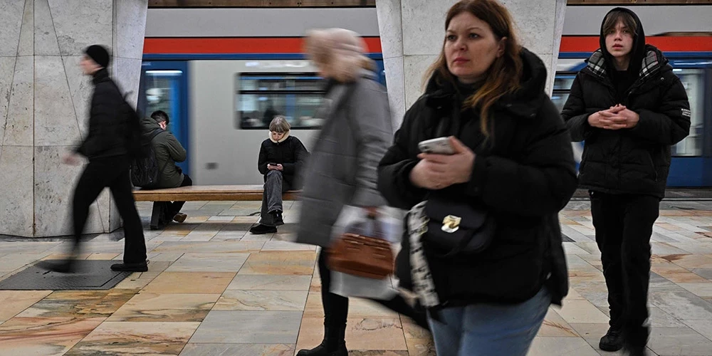 Maskavas iedzīvotāji metro savos viedtālruņos mēģina lietot internetu.