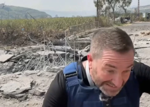 "Russia Today" propagandas filmēšanas grupas komanda glābjas no raķešu trieciena.