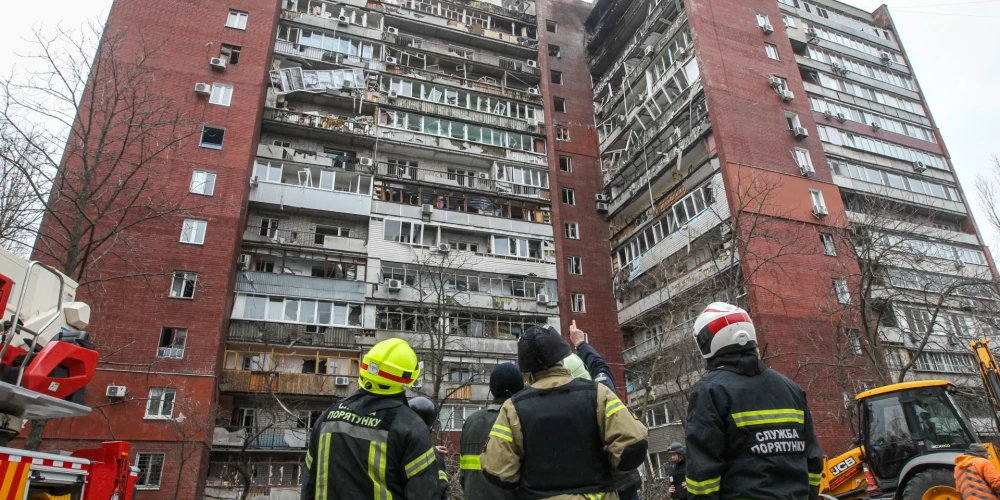 Пожарные осматривают 14-этажный жилой дом, поврежденный в результате удара российского беспилотника по Днепру 24 марта 2026 года.