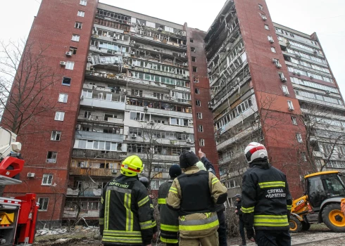 Пожарные осматривают 14-этажный жилой дом, поврежденный в результате удара российского беспилотника по Днепру 24 марта 2026 года.
