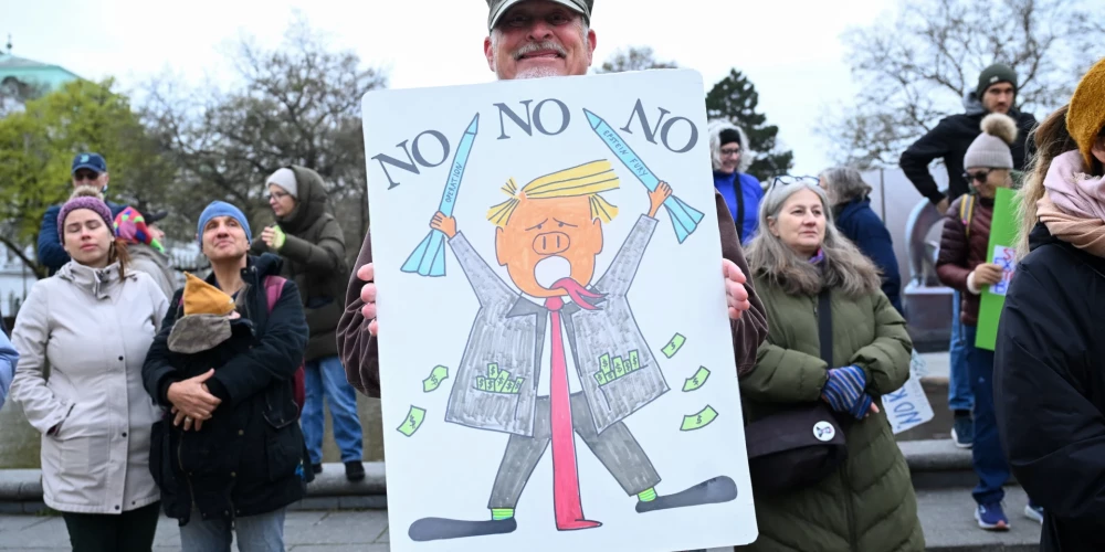 Demonstrants Austrijā tur plakātu ar ASV prezidenta Donalda Trampa karikatūru