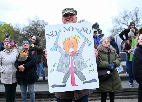 Demonstrants Austrijā tur plakātu ar ASV prezidenta Donalda Trampa karikatūru