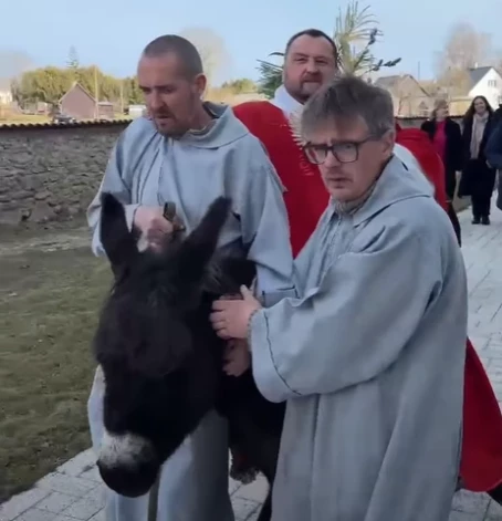 Skaistkalnes baznīcas priesteris Andrejs Mediņš jāj uz ēzeļa (ekrānuzņēmums no video)