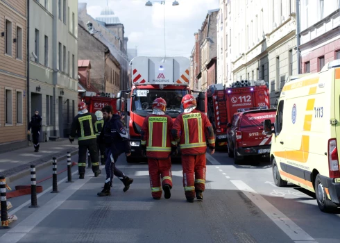 В Риге пожарные с автолестницами и автоцистернами тушат загоревшийся жилой дом.
