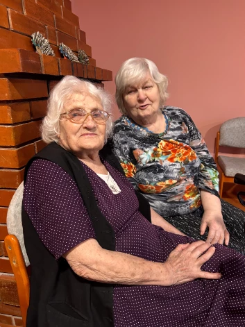 Lūcija ir SAC Ruba vecākā iemītniece. Viņai patīk pajokot un uzdziedāt. Lūcijai blakus — Skaidrīte.