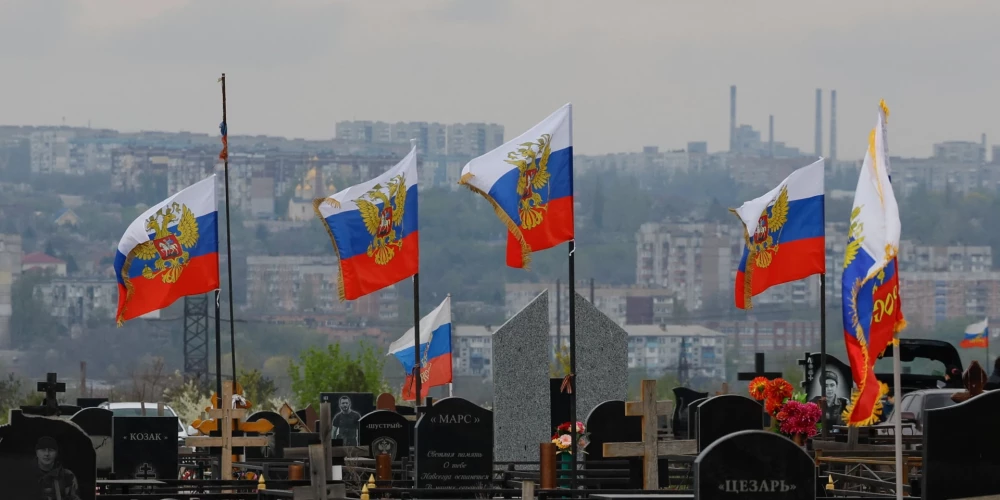 Krievijas karogi plīvo kapsētā okupētajā Ukrainas pilsētā Doneckā.