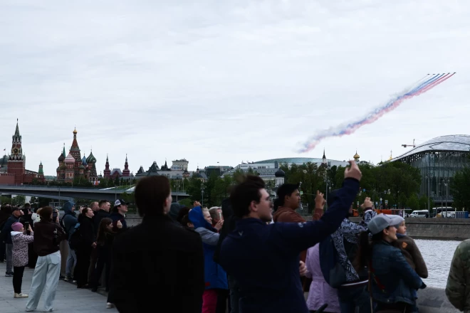 Cilvēki Maskavā vēro "uzvaras" dienas parādi.