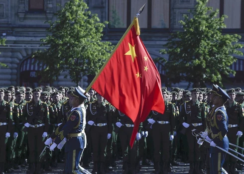 Ķīnas Tautas atbrīvošanas armijas karavīri nes karogu pirms Uzvaras dienas militārās parādes, kas veltīta nacistu sakāves 75. gadadienai Sarkanajā laukumā Maskavā. 2020. gada 24. jūnijs.
