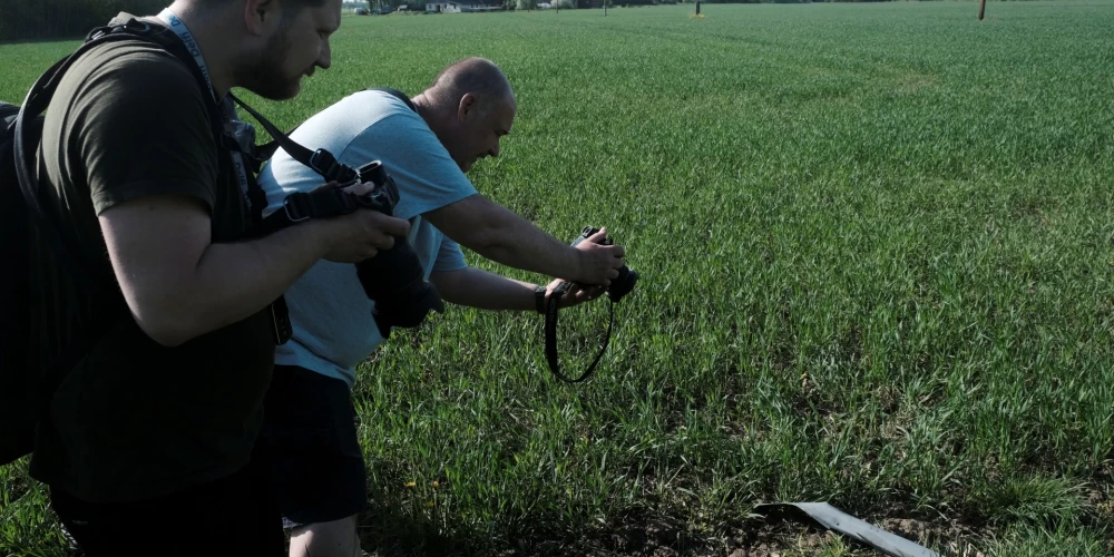 Žurnālisti fotografē notriektā drona daļas (foto: Scanpix / EPA)