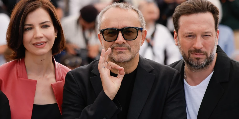 Īrisa Ļebeģeva, režisors Andrejs Zvjagincevs un Dmitrijs Mazurovs pozē fotogrāfiem 79. Starptautiskajā Kannu filmu festivālā Dienvidfrancijā.