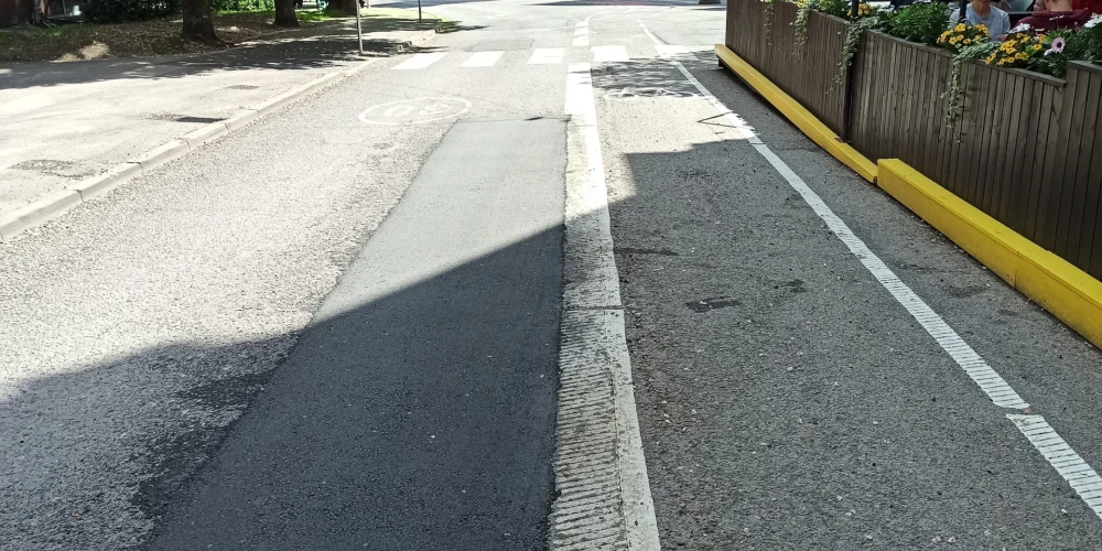 Uz jaunā ielu marķējuma palikuši netīri tehnikas riepu nospiedumi.