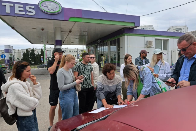 Жители Севастополя записываются в списки, чтобы занять очередь за бензином после введения ограничений на продажу топлива, Севастополь, Украина, 1 июня 2026 года.