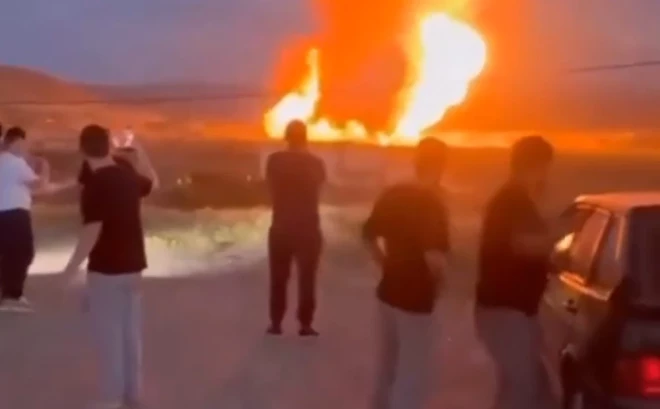 Iedzīvotāji filmē liesmojošo uguns stabu.
